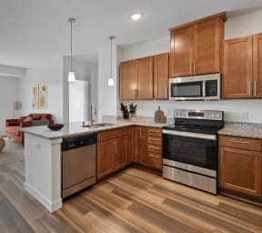 an open kitchen and living room with wooden floors and wooden cabinets