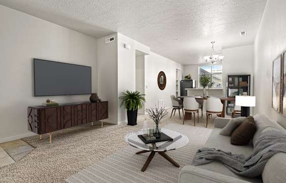 A living room with a grey couch, a coffee table, and a television.