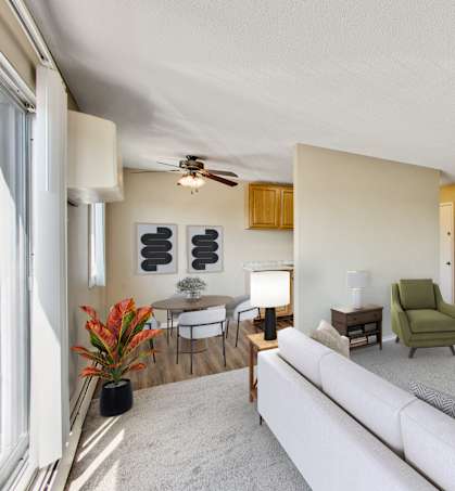 A living room with a white couch, a green chair, and a wooden coffee table at Northtown Village Apartments, Spring Lake Park, MN 55432-2650