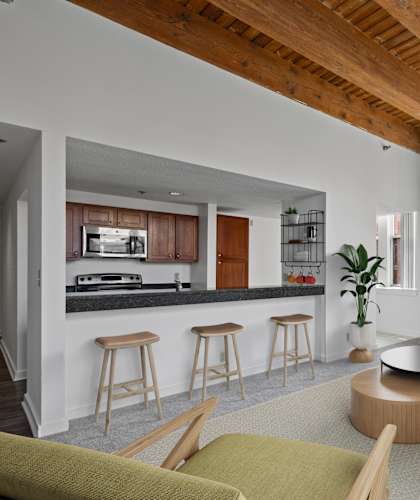 A living room with a bar area and a kitchen in the background.