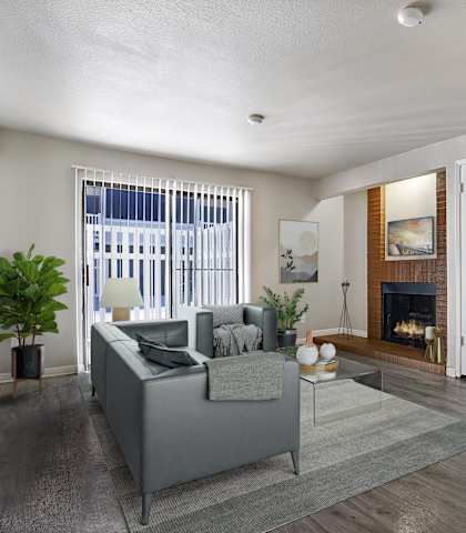 A living room with a grey couch and a fireplace.