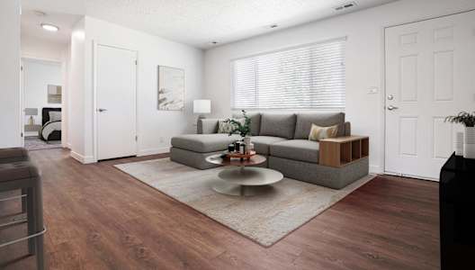 A living room with a grey couch and a coffee table.