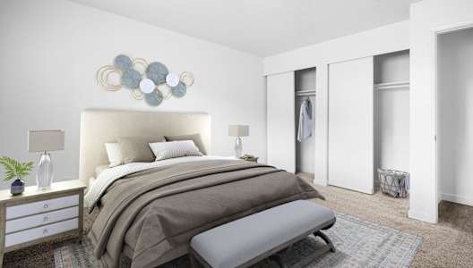 A bedroom with a large bed and a bench in front of it.