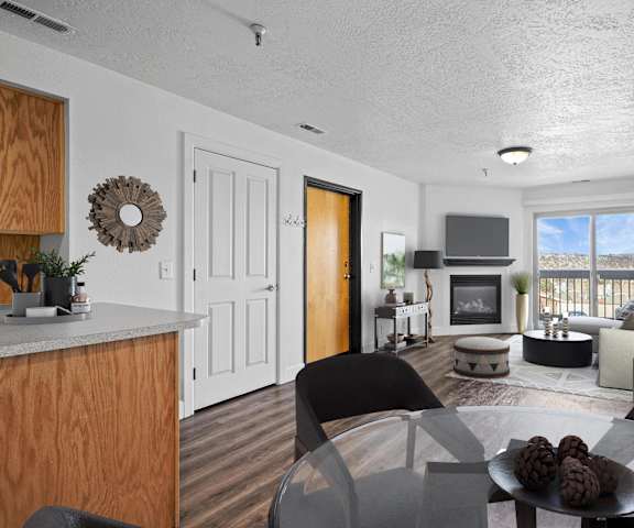 A modern living room with a wooden cabinet and a glass table.