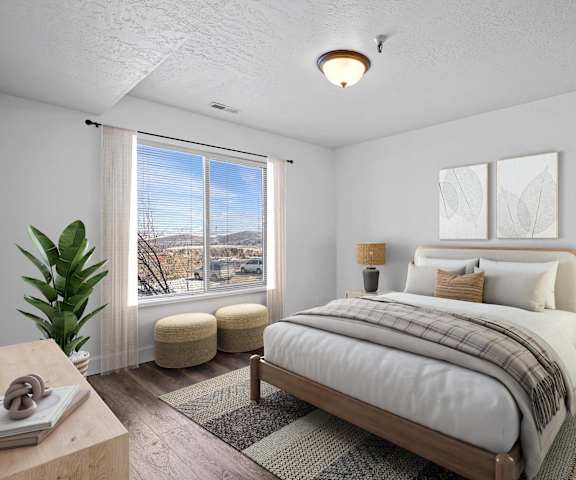 A bedroom with a large bed and a view of the outside through the window.