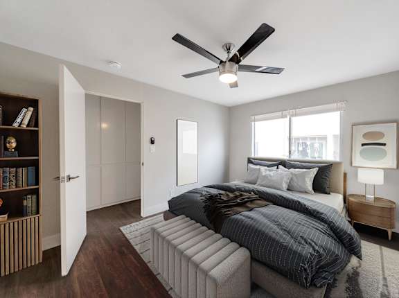 A bedroom with a large bed and a ceiling fan at Oasis Apartments, Burbank, CA