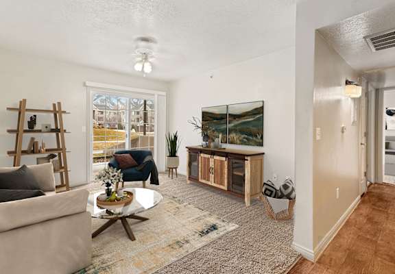 A living room with a couch, coffee table, and a painting on the wall.