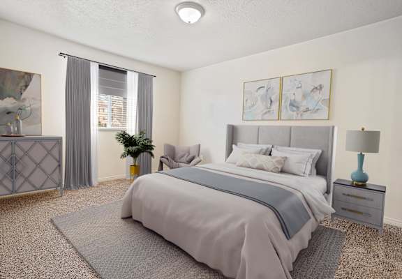 A bedroom with a large bed and a nightstand with a lamp.