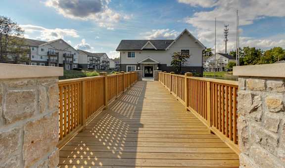 a wooden bridge with a house in the background