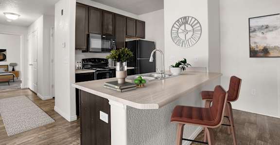 A kitchen with a brown chair and a white counter.