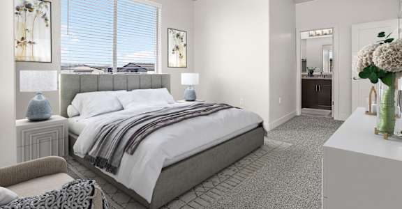 A bedroom with a large bed and a chair.