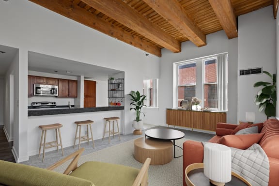 a living room with a couch and a kitchen with a counter and a window