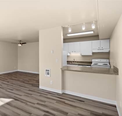 an empty living room and kitchen with a wood floor