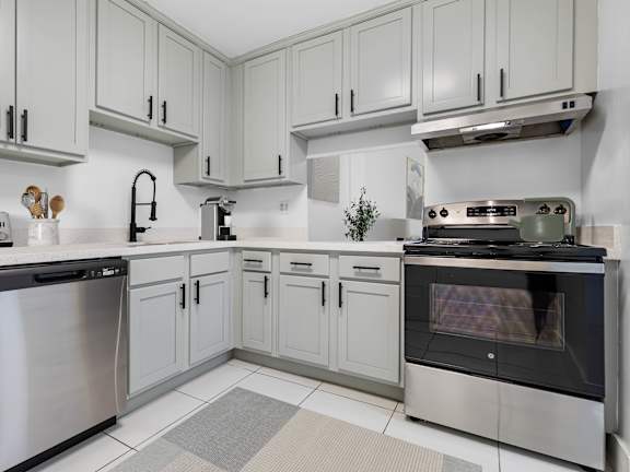 A modern kitchen with stainless steel appliances and white cabinets.