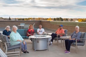 a group of people sitting around a round table on a roof