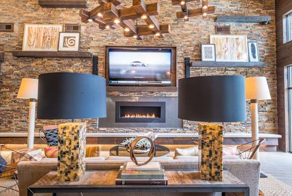 A living room with a stone wall and a fireplace.