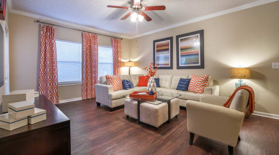 a living room with couches and chairs and a ceiling fan