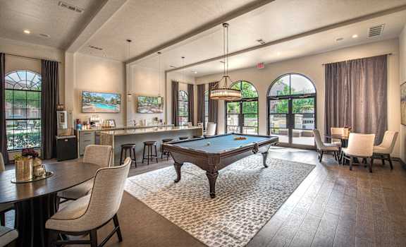 A large room with a pool table and a bar.