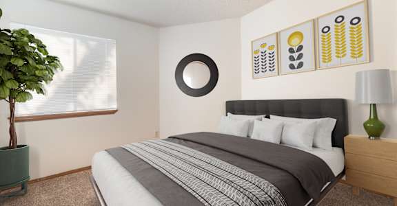 A bedroom with a large bed and a green plant.