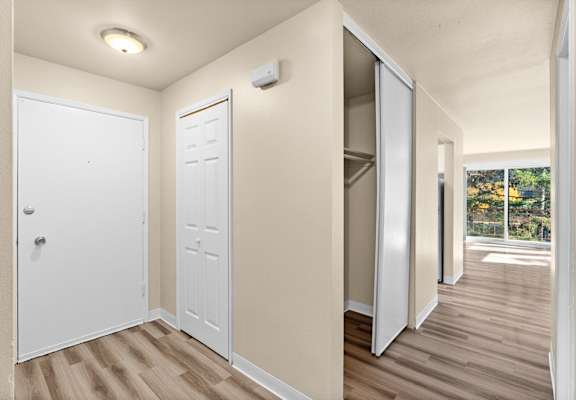 an empty room with doors to a closet and a window