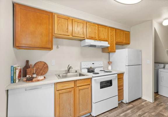 A kitchen with wooden cabinets and white appliances.