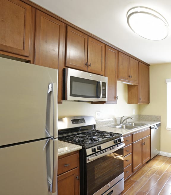a kitchen with wooden cabinets and stainless steel appliances