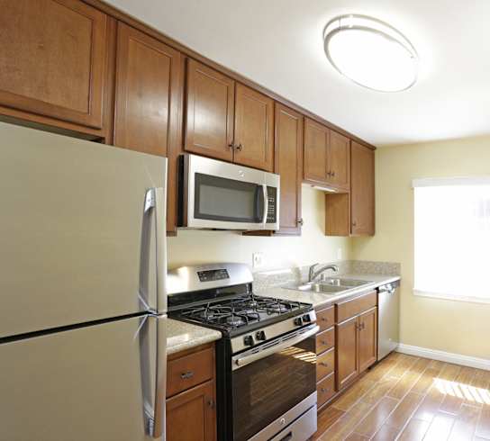 a kitchen with wooden cabinets and stainless steel appliances