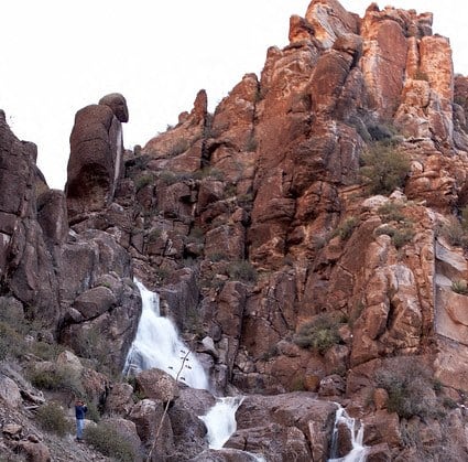 a man standing in front of a waterfall