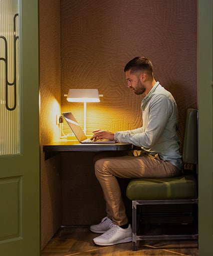 a man sitting at a desk using a laptop computer