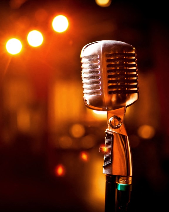 a microphone in a dark room with lights in the background
