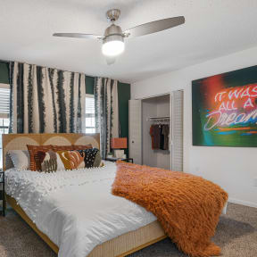 a bedroom with green walls and a large bed with a white comforter and an orange
