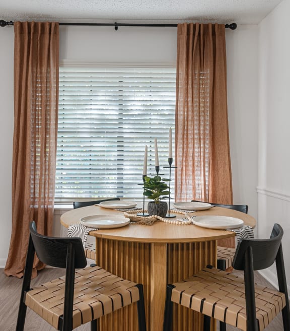 a dining area with a wooden table and four chairs