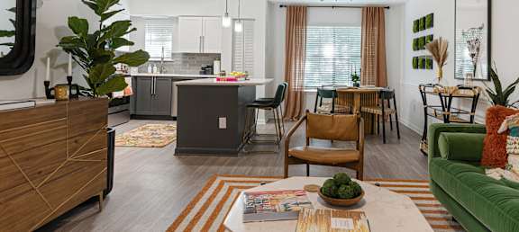 an open concept living room and kitchen with a dining room table and chairs and a kitchen island