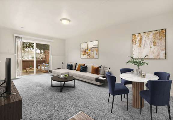 A living room with a grey carpet and a white table.