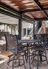 a patio with a table and chairs and a grill
