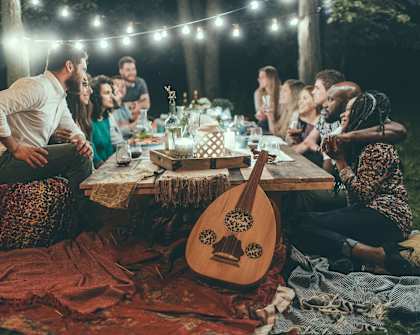 a group of people sitting around a picnic table with a guitar