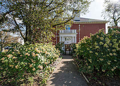 A pathway leads to a building with a balcony.