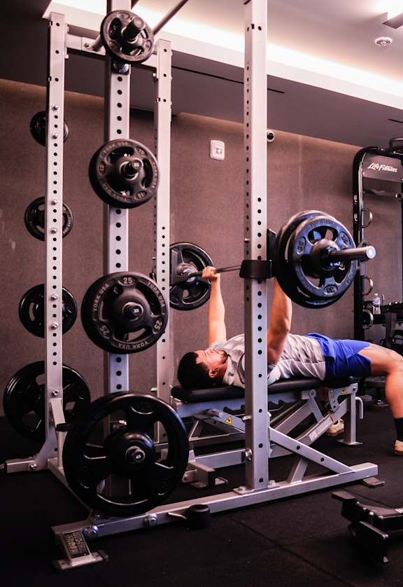 a man laying on a bench in a gym with weights