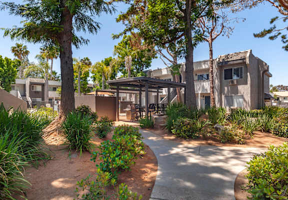 a courtyard with trees and plants at the whispering winds apartments in pearland, tx