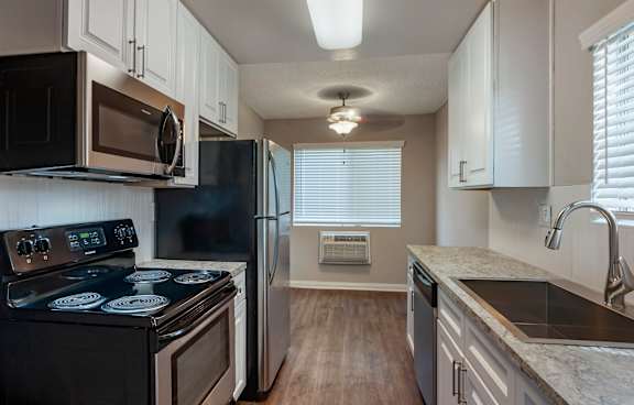 A modern kitchen with a white island and stainless steel appliances.