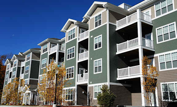 A large apartment building with balconies and multiple stories.