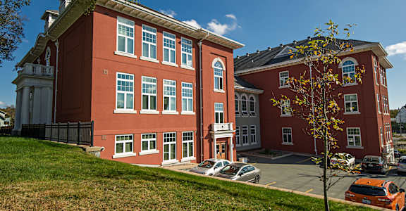 A red building with a tree in front of it.