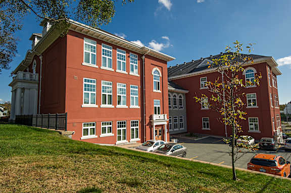 A red building with a tree in front of it.