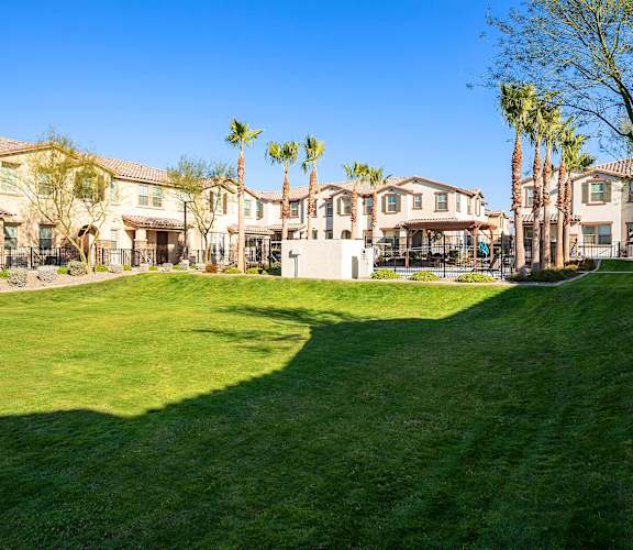 A large grassy area in front of a row of houses. at Casa Sole Vita Townhomes, Arizona
