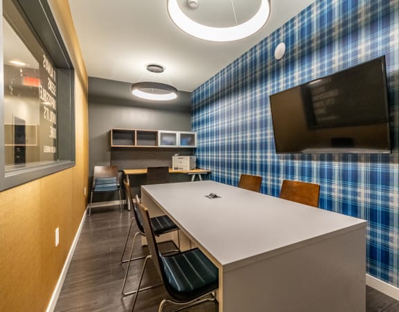 a meeting room with a blue plaid wall and a table with chairs