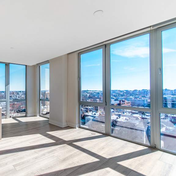 A large empty room with a view of the city.