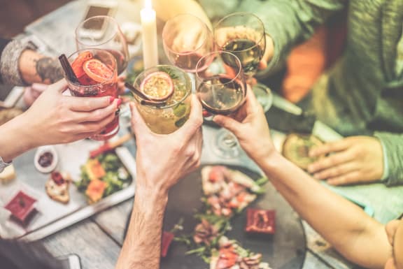 a group of people holding up wine glasses over a table