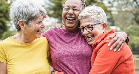 a group of women laughing in a park