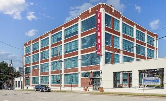 a large brick building with a red sign on the side of it