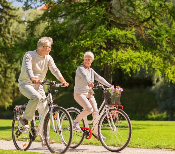 Grand Forks, ND Stanford Court Apartments | a man and a woman riding bikes in a park